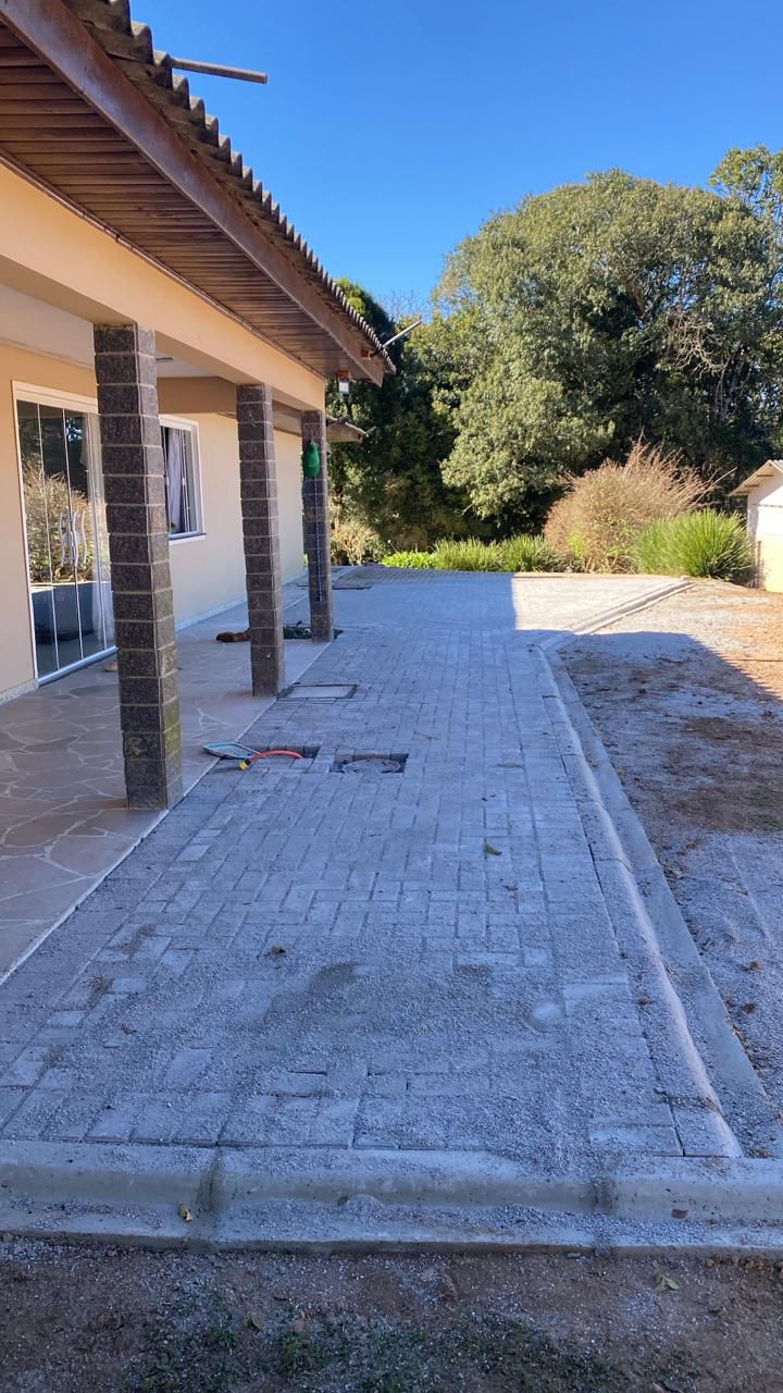 Caminho lateral de residência com paver cinza e acabamento de concreto